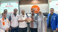 Politikus Partai Amanat Nasional (PAN), Bima Arya, menyerahkan bingkisan jeruk oranye berpita biru saat mendatangi markas DPW Jawa Barat PKS, Kota Bandung, Senin, 10 Juni 2024. (Dok. PAN).
