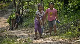 Siswa sekolah dasar mendaki bukit Temulawak mencari sinyal internet sebelum mengikuti pembelajaran secara online menggunakan smartphone di Yogyakarta, Jumat (8/5/2020). Mereka ke atas bukit untuk mendapat sinyal yang bagus agar kegiatan belajar secara online dapat berlangsung. (AGUNG SUPRIYANTO/AFP)