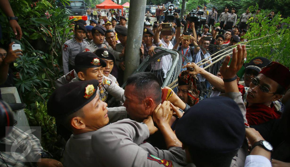 Seorang pria yang diduga provokator diamankan dari amukan massa saat sidang kasus penistaan agama di Jakarta, Selasa (10/1). Sempat terjadi kericuhan akibat peristiwa tersebut. (Liputan6.com/Immanuel Antonius)
