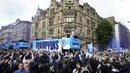 Para pemain Manchester City menyapa para penggemar dari atas bus saat parade kemenangan Liga Inggris di Manchester, Inggris, 23 Mei 2022. (AP Photo/Jon Super)