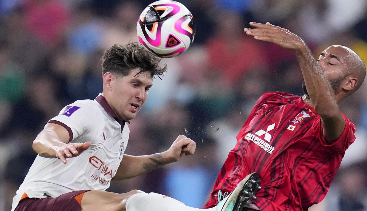 Bek Manchester City, John Stones (kiri) berebut bola dengan striker Urawa Red Diamonds, Jose Kante pada laga semifinal Piala Dunia Klub 2023 di King Abdullah Sports City Stadium, Jeddah, Arab Saudi, Rabu (20/12/2023) dini hari WIB. (AP Photo/Manu Fernandez)