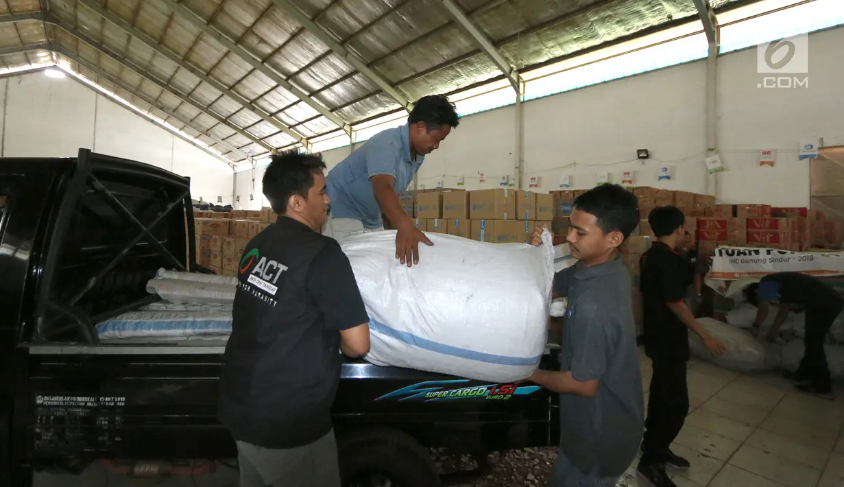 Petugas menurunkan bantuan 4 tenda darurat dan kebutuhan lainnya dari PT Jakarta International Container Terminal (JICT) untuk korban gempa dan tsunami di Palu dan Donggala di Gudang IHC-ACT Parung, Bogor, Jumat (12/10). (Liputan6.com/HO/Arif)