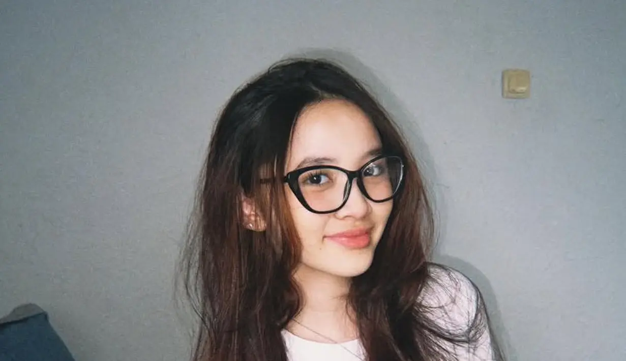 Sybil sering menggerai rambut panjangnya di setiap kesempatan. Dengan gaya messy ia pun menggerai rambutnya sambil mengenakan kaos putih dan kacamatanya.  [@kana.sybilla]