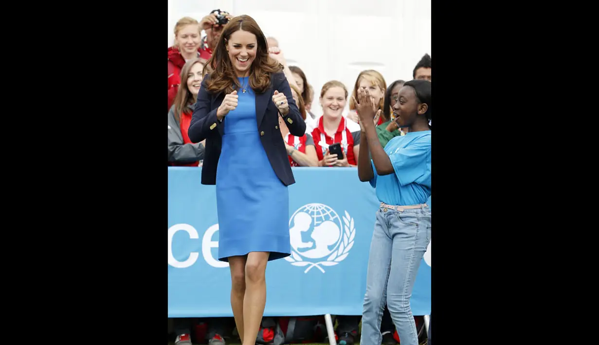 Salah satu anak menyambut keberhasilan Duchess of Cambridge, Kate Middleton, memainkan permainan asli Afrika Selatan "Tiga Kaleng" di Commonwealth Games Village di Glasgow, Skotlandia, (29/7/2014). (REUTERS/Danny Lawson)