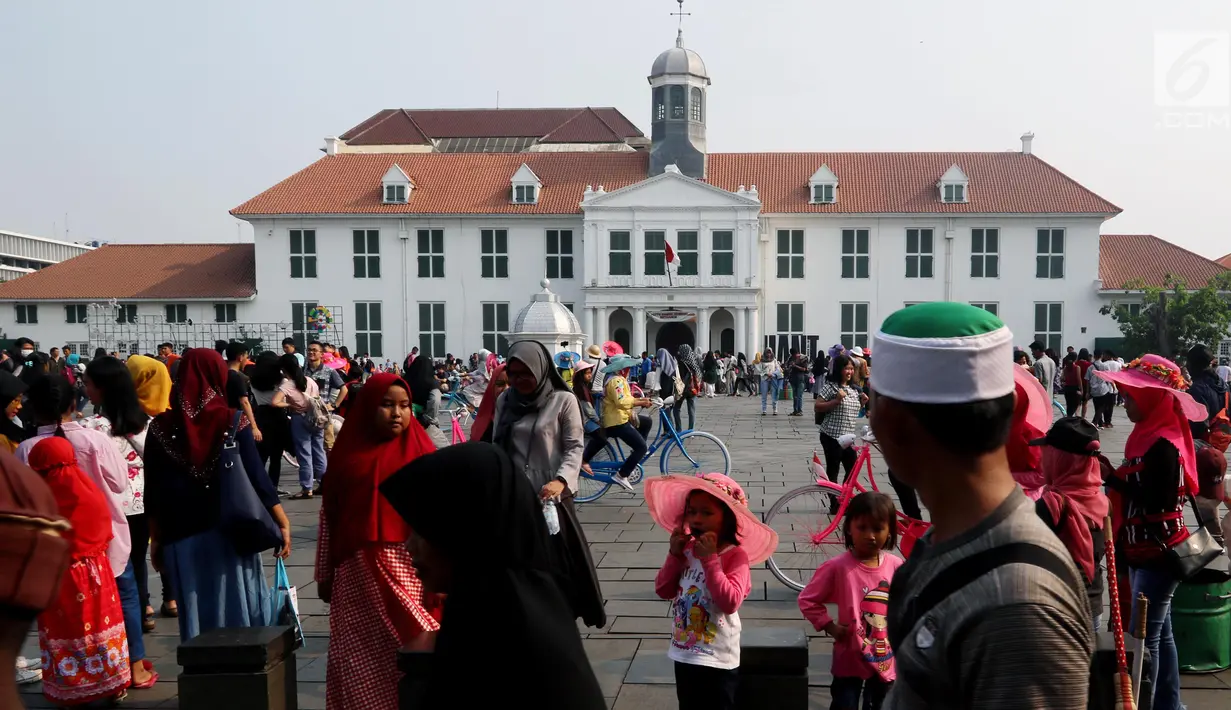 Wisatawan menikmati suasana kawasan Kota Tua, Jakarta, Selasa (20/11). Libur Maulid Nabi 2018 dimanfaatkan warga untuk berwisata di sejumlah lokasi, Salah satu yang ramai dikunjungi yakni Kota Tua. (Liputan6.com/Johan Tallo)