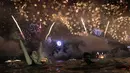 Seorang wanita menyaksikan pesta kembang api menyambut Tahun Baru 2019 di Pantai Copacabana, Rio de Janeiro, Brasil, Selasa (1/1). (AP Photo/Leo Correa)
