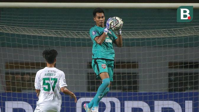 Kiper Borneo FC, Angga Saputro menangkap bola saat melawan Persebaya dalam laga pekan pertama BRI Liga 1 2021/2022 di Stadion Wibawa Mukti, Cikarang, Sabtu (04/09/2021). Borneo FC menang 3-1. (Foto: Bola.com/Bagaskara Lazuardi)