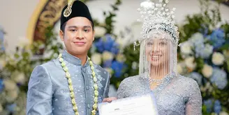 Atheera pun lengkap mengenakan mahkota pengantin adat Betawi Siangko. Mahkotanya memiliki cadar yang berwarna silver dilengkapi kembang goyang di bagian belakang. [@sandiuno]