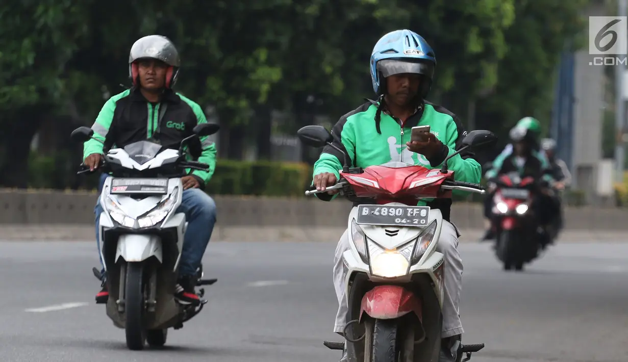 Pengemudi ojek online mengoperasikan telepon seluler sambil mengendarai sepeda motor di Jalan Gatot Subroto, Jakarta, Kamis (8/3). Polisi menilai tindakan itu membahayakan karena  pengemudi menjadi tidak fokus di jalan raya. (Liputan6.com/Arya Manggala)