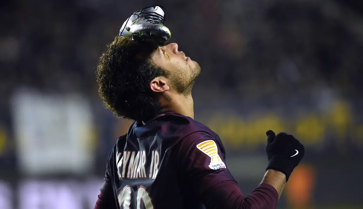 Pemain Paris Saint-Germain (PSG), Neymar melakukan selebrasi unik setelah menjebol gawang SC Amiens pada laga Piala Liga Prancis di Stade de la Licorne, Rabu (10/1). Usai mencetak gol, Neymar menaruh sepatu di keningnya. (FRANCOIS LO PRESTI/AFP)