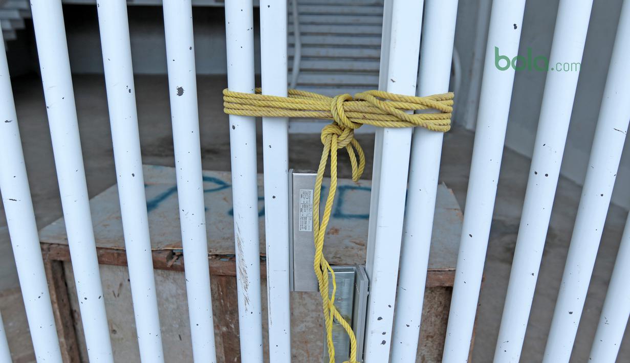 Piintu stadion yang rusak sementara diikat dengan tali sebelum perbaikan di Stadion Utama Gelora Bung Karno, Kamis (22/2/2018). Empat pintu stadion yang mengalami kerusakan adalah zona bernomor 5B, 7B, 9, dan 10. (Bola.com/Nick Hanoatubun)