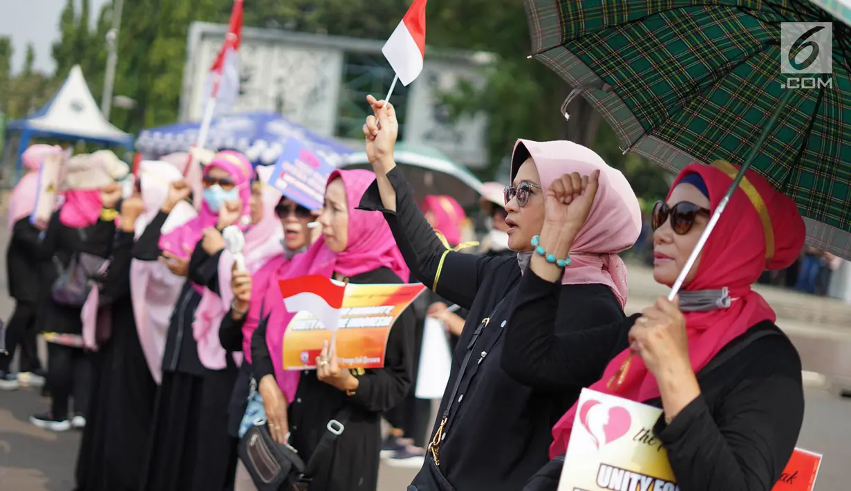 Massa yang tergabung dalam Presidium Perempuan Indonesia membawa bendera Merah Putih saat menggelar aksi damai di depan Istana Negara, Jakarta, Kamis (16/5/2019). Massa menuntut Presiden Joko Widodo mengambil sikap atas dugaan kecurangan dalam Pemilu 2019. (Liputan6.com/Immanuel Antonius)