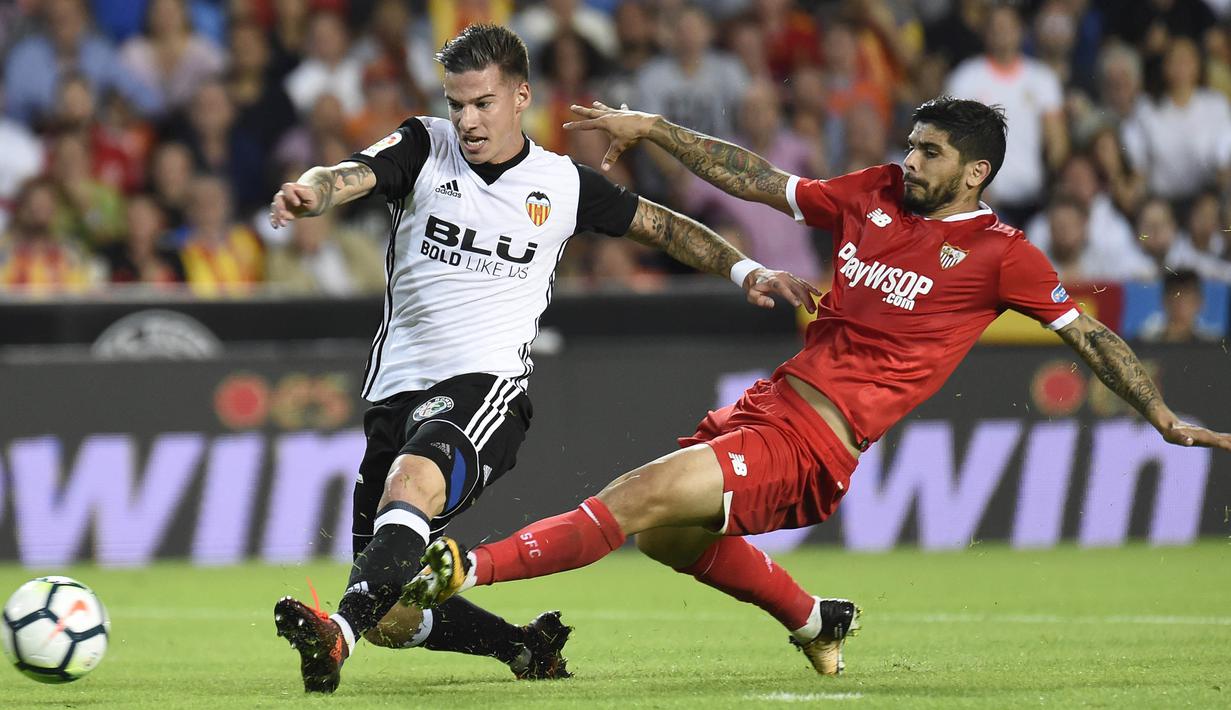 Striker Valencia, Santi Mina, berebut bola dengan gelandang Sevilla, Ever Banega, pada laga La Liga Spanyol di Stadion Mestalla, Sabtu (21/10/2017). Valencia menang 4-0 atas Sevilla. (AFP/Jose Jordan)