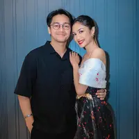 Dalam riasan dengan lipstik merah merekah, ia ditemani sang suami Deva Mahenra. [Foto: @miktambayong]