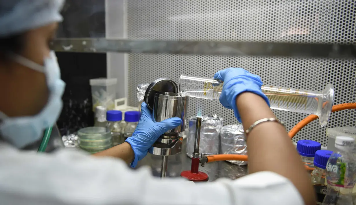 Seorang asisten laboratorium mikrobiologi memeriksa kualitas air di pabrik air mineral alami Aava di Ahmedabad, India (19/3). Hari Air Sedunia jatuh pada tanggal 22 Maret. (AFP Photo/Sam Panthaky)