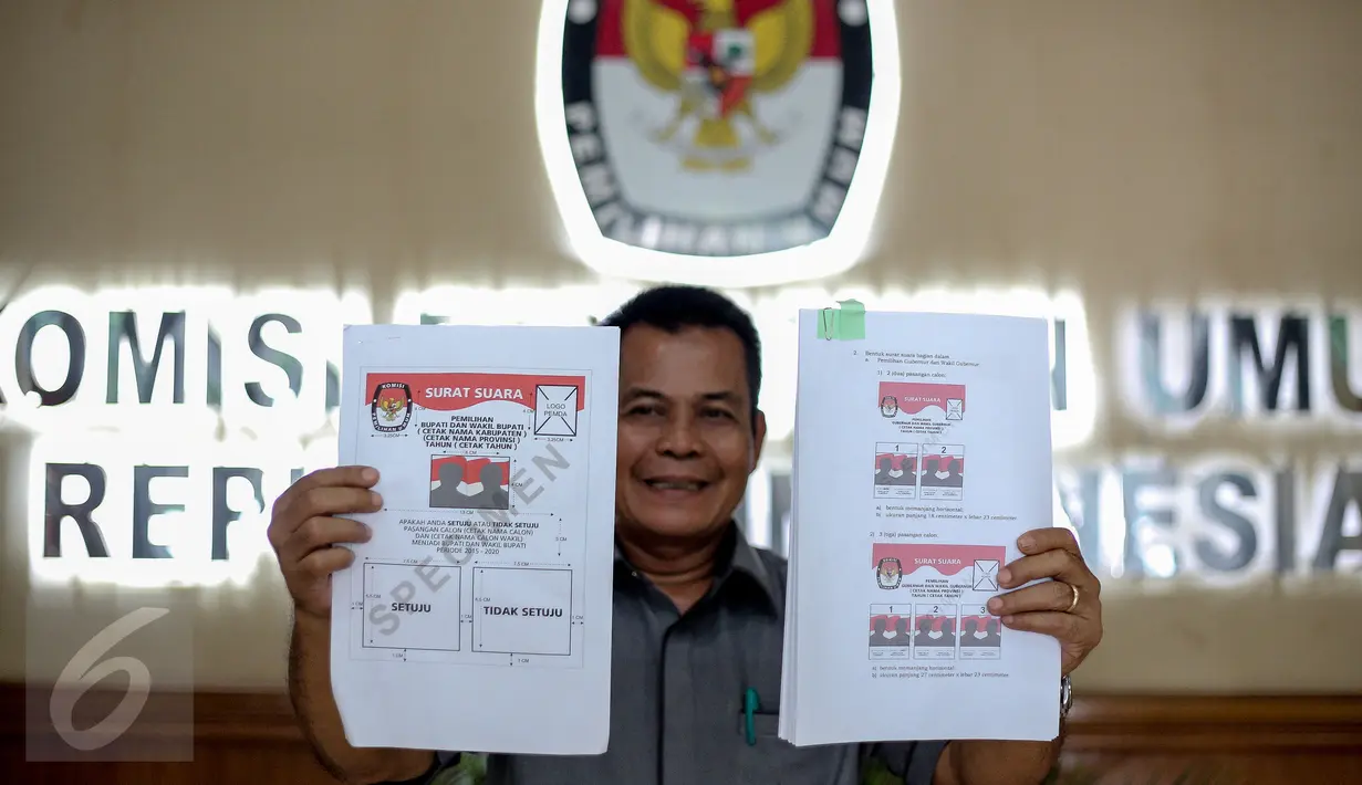 Kepala Subag Penyusunan Norma Desain dan Standar Kebutuhan Pemilu Biro Perencanaan Data KPU Sahono  menunjukan dua contoh surat suara untuk Pilkada Serentak 9 Desember 2015 di Gedung KPU, Jakarta, Rabu (11/11). (Liputan6.com/Faizal Fanani)