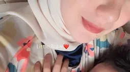Momen kebersamaan ini terasa semakin hangat dengan kehadiran anak mereka yang tengah tertidur pulas di pangkuan Irish. Meski sederhana, kehadiran si kecil memberi warna tersendiri dalam perjalanan mereka di pagi hari. (Liputan6.com/IG/@_irishbella_)