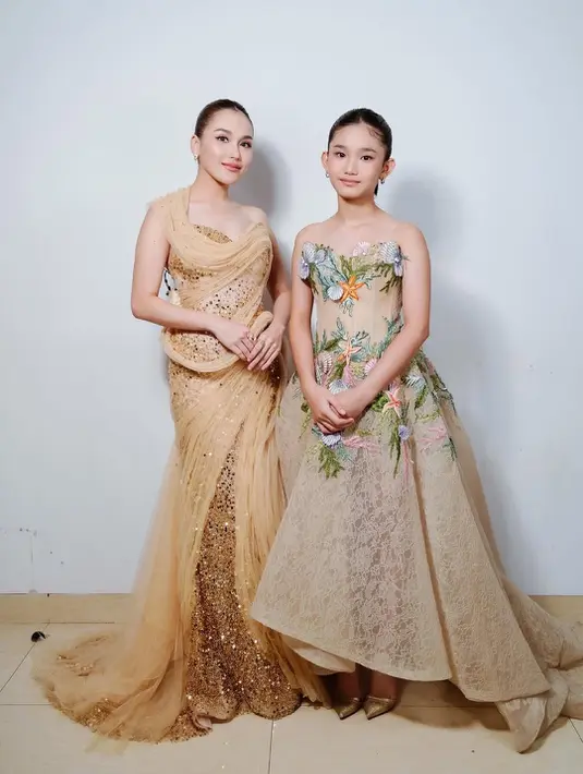 Pasangan ibu anak ini kompak dalam balutan bernuansa nude gold. Ayu Ting-Ting kenakan sequin gold dress dari Felissa Thung. Gaun ini memiliki one shoulder tulle drappery yang jatuh hingga melantai [@ayutingting92]