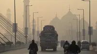 Kendaraan melintas di tengah kondisi kabut asap tebal di Lahore, Pakistan,  pada 17 November 2021. Kota dengan lebih dari 11 juta orang di Provinsi Punjab dekat perbatasan dengan India ini secara konsisten menempati peringkat di antara kota-kota berpolusi udara terburuk di dunia. (Arif ALI/AFP)