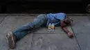 Seorang pria tunawisma tidur siang di trotoar dengan dua botol air di depannya di daerah Skid Row Los Angeles, Rabu (31/8/2022). Peringatan panas berlebihan meluas ke seluruh California Selatan dan ke utara ke Central Valley pada Rabu , dan diperkirakan akan menyebar ke California Utara pada akhir minggu ini. (Foto AP/Jae C.Hong)