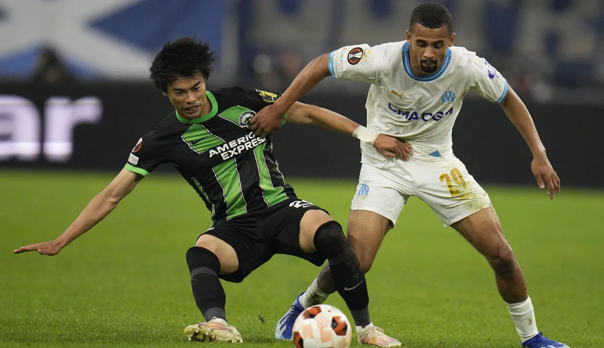 Pemain Brighton, Kaoru Mitoma (kiri) berebut bola dengan pemain Marseille, Iliman Ndiyae pada laga Grup B Liga Europa 2023/2024 di Stade Velodrome, Marseille, Prancis, Jumat (05/10/2023) dini hari WIB. (AP Photo/Daniel Cole)