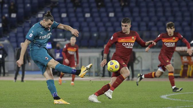Penyerang AC Milan,  Zlatan Ibrahimovic menembak bola saat bertanding melawan AS Roma pada pertandingan lanjutan Liga Serie A Italia di stadion Olimpiade, di Roma, Italia,Senin (1/3/2021). Saat ini AC MIlan mengemas 52 poin terpaut 4 poin dari Inter Milan. (AP Photo/Gregorio Borgia)