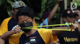 Peserta membidik sasaran saat lomba ketapel di Kampoeng Ketapel, Ciganjur, Jakarta, Minggu (19/9/2021). Ketapel diharapkan bisa menjadi salah satu olahraga prestasi yang diakui KONI. (Liputan6.com/Herman Zakharia)