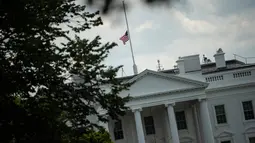 Pemandangan bendera nasional AS yang berkibar setengah tiang di Gedung Putih, Washington DC, Minggu (4/8/2019). Presiden Donald Trump memerintahkan bendera dikibarkan setengah tiang selama lima hari sebagai simbol dukacita atas dua penembakan massal di El Paso, Texas, dan Ohio. (Eric BARADAT/AFP)