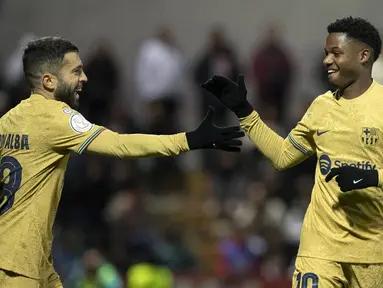 Pemain Barcelona Ansu Fati (kanan) merayakan dengan Jordi Alba setelah mencetak gol ke gawang AD Ceuta pada pertandingan sepak bola babak 16 besar Copa del Rey di Stadion Alfonso Murube, Ceuta, Spanyol, 19 Januari 2023. Barcelona mengalahkan AD Ceuta dengan skor 5-0. (JORGE GUERRERO/AFP)