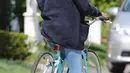 Selena terlihat bahagia mengendarai sepedanya dengan meneganakan cardigan berwarna navy dan kaus putih. (BACKGRID/USMagazine)