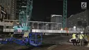 Petugas menggunakan alat berat merobohkan Jembatan Penyeberangan Orang (JPO) di Kawasan Bundaran HI, Jakarta, Senin (30/7/2018) malam. Pembongkaran JPO ini juga terkait upaya mempercantik ibu kota jelang Asian games 2018. (Liputan6.com/Herman Zakharia)