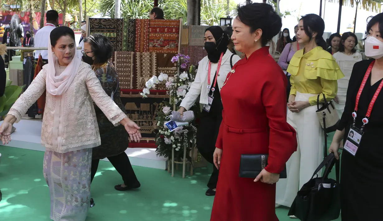 <p>Ibu Negara Indonesia Iriana Joko Widodo (kanan) menyapa Ibu Negara China Peng Liyuan (tengah), Ibu Negara Korea Selatan Kim Keon-hee (kedua dari kanan) selama rangkaian kegiatan Konferensi Tingkat Tinggi (KTT) G20 di Sofitel Bali Nusa Dua Beach Resort, Nusa Dua, Bali, Indonesia, Selasa (15/11/2022). Selama kegiatan berlangsung para Ibu Negara dan Istri Perdana Menteri menyaksikan demo kerajinan daun lontar, proses membatik, hingga proses menenun. (AP Photo/Firdia Lisnawati via Pool)</p>