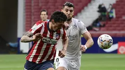 Bek Atletico Madrid, Stefan Savic (kiri) berebut bola dengan striker SD Huesca, Rafa Mir dalam laga lanjutan Liga Spanyol 2020/2021 pekan ke-32 di Wanda Metropolitano Stadium, Madrid, Kamis (22/4/2021). Atletico menang 2-0 atas SD Huesca. (AFP/Javier Soriano)
