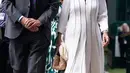 Di bagian alas kaki, sang figur publik melangkah dengan sepasang sepatu hak tinggi berbahan suede berwarna abu-abu muda. (Victoria Jones / POOL / AFP)