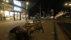 Skuter yang terbakar tergeletak di trotoar di luar restoran cepat saji yang hancur sebagai protes terhadap jam malam nasional di Rotterdam, Belanda, Senin (25/1/2021). Mulai 23 Januari, jam malam dimulai di Belanda dari pukul 21.00 hingga 04.30 untuk mengendalikan COVID-19. (AP Photo/Peter Dejong)