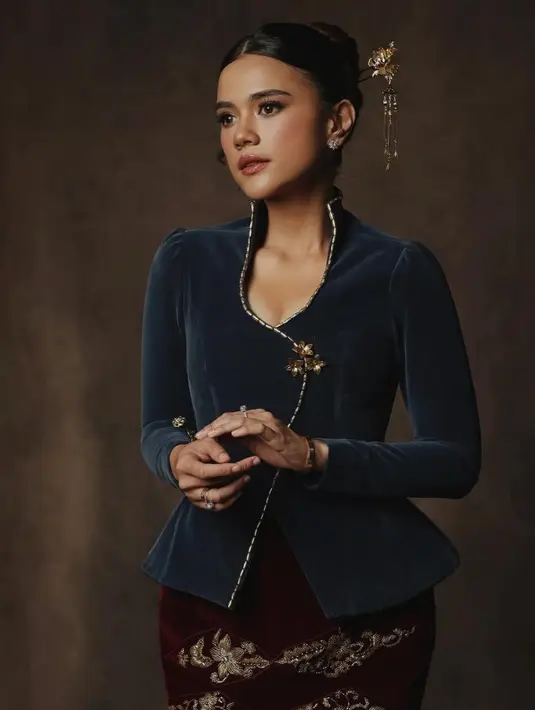 Audi Marissa elegan dibalut kebaya hijau velvet kerah tinggu dengan aksen list gold dipadukan bros emas dan bawahan rok velvet dengab aksen gold. [@audimarissa]
