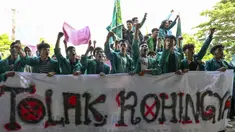 Mahasiswa memegang spanduk bertuliskan “Tolak Rohingya” saat berdemonstrasi menentang kedatangan pengungsi Rohingya di depan Dewan Perwakilan Rakyat (DPR) di Banda Aceh, Rabu (27/12/2023). Aksi diikuti oleh ratusan mahasiswa dari berbagai universitas. (CHAIDEER MAHYUDDIN/AFP)