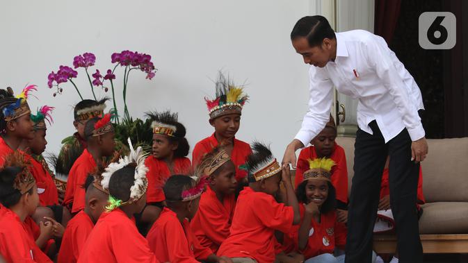 Presiden Joko Widodo atau Jokowi menyalami perwakilan anak-anak sekolah dasar dari Papua di Istana Merdeka, Jakarta, Jumat (11/10/2019). Jokowi mengaku sudah berjanji untuk mengundang mereka ke istana saat mengunjungi Jayapura dan Asmat. (Liputan6.com/Angga Yuniar)