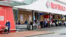 Orang-orang mengantre di luar supermarket di pinggiran kota Devonport di Auckland, Rabu (12/8/2020). Pemerintah Selandia Baru memberlakukan lockdown level 3 di Auckland setelah ditemukan 4 kasus baru COVID-19 di kota itu. (DAVID ROWLAND / AFP)