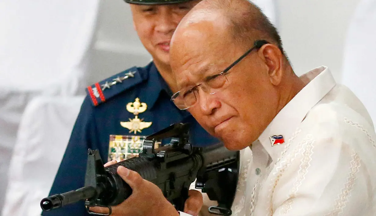 Menhan Filipina Delfin Lorenzana mencoba senapan serbu yang dihibahkan China, Manila, Filipina (5/10). Ribuan senapan serbu senilai US$ 3,3 juta (Rp 43,7 miliar) akan diserahkan seluruhnya ke Kepolisian Nasional Filipina (PNP). (AP Photo/Bullit Marquez)