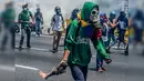 Demonstran bersenjatakan bom molotov saat demonstrasi menentang Presiden Nicolas Maduro di Caracas,  Venezuela, Rabu (26/4). Hingga kini, bentrokan antara demonstran dan polisi telah menyebabkan 26 orang tewas. (AFP PHOTO) 