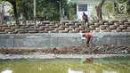 Pekerja menyelesaikan pembuatan turap bermaterialkan ban bekas di Kali Karang Bolong, Ancol, Jakarta, Rabu (4/9/2019). Suku Dinas Sumber Daya Air (SDA) menggunakan 2.400 ban bekas truk sampah sebagai turap dalam program naturalisasi di sepanjang 400 meter. (Liputan6.com/Immanuel Antonius)