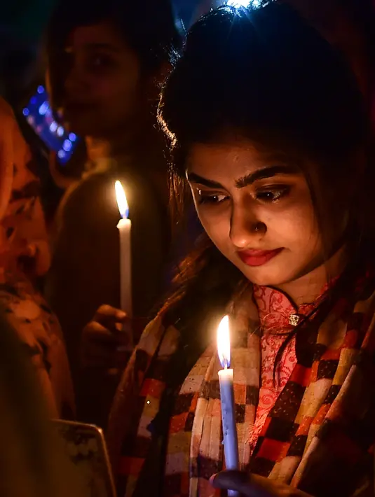 Wanita Bangladesh memegang lilin untuk memperingati Hari Perempuan Internasional di Dhaka (7/3). Hari Perempuan Internasional jatuh pada tanggal 8 Maret setiap tahunnya. (AFP Photo/Munir Uzzaman)