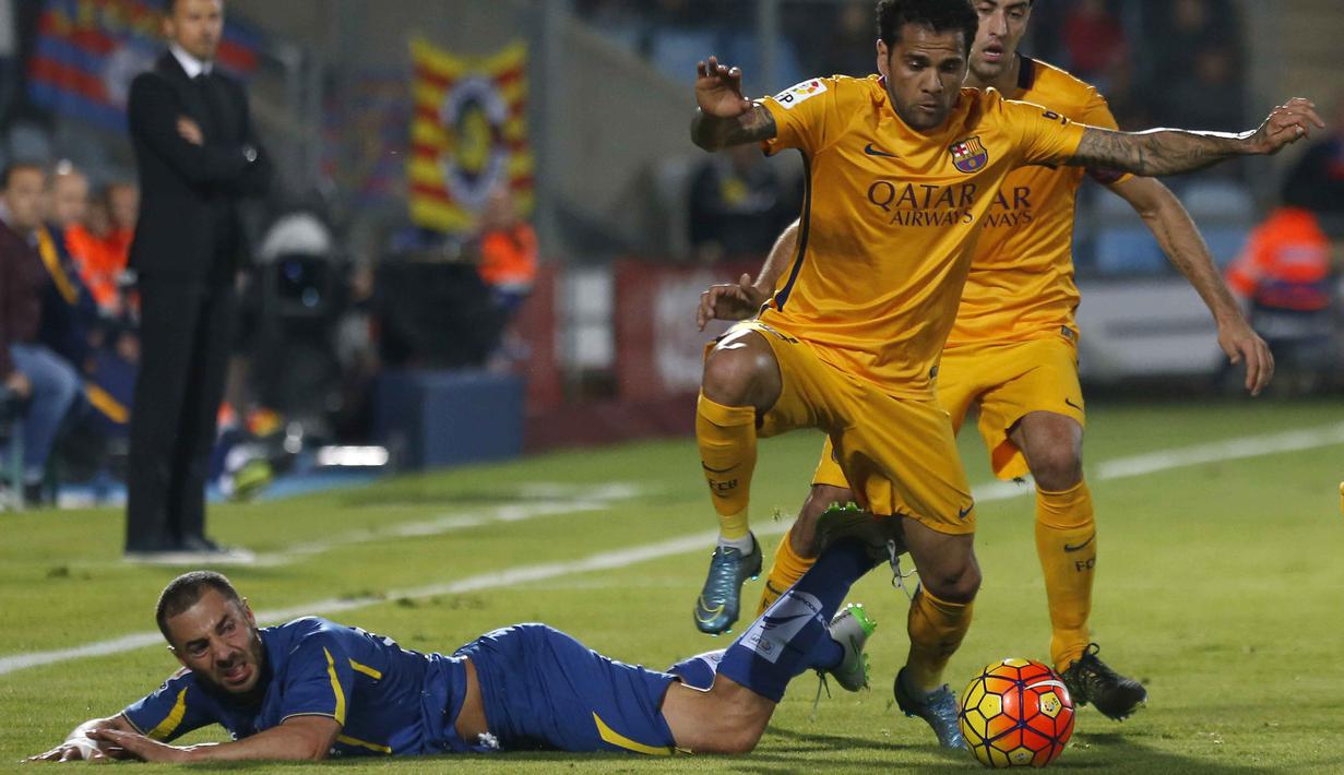 Pemain Barcelona Dani Alves berebut bola dengan pemain Getafe Mehdi Lacen (jatuh) dalam lanjutan La Liga Spanyol di Stadion Coliseum Alfonso Perez,  Getafe, Madrid, Sabtu (31/10/2015) Barcelona menang 2-0. (EPA/Javier Lizon)