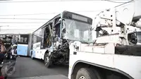 Badan bus Transjakarta dipindahkan dari lokasi kecelakaan di perlintasan Jalan Mangga Dua, Jakarta, Kamis (19/5). Sebelumnya, sebuah kecelakaan terjadi melibatkan bus transjakarta, mobil Avanza dan Kereta Senja Utama Solo. (Liputan6.com/Faizal Fanani)