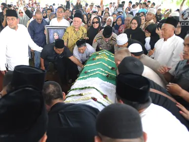 Keluarga dan jemaah saat akan memakamkan jenazah Hj. Djuriah Rais atau dikenal dengan nama Dian Al Mahri ke dalam liang lahat di area Masjid Kubah Emas, Cinere, Depok, Jumat (29/3). Pendiri Masjid Kubah Emas itu meninggal dunia pada Jumat dini hari tadi di usia 70 tahun. (merdeka.com/Arie Basuki)