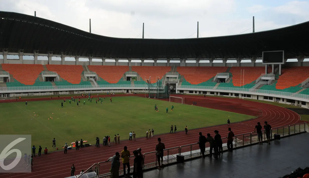 Warga melihat pemain timnas Indonesia berlatih jelang latihan seleksi di Stadion Pakansari, Bogor, Selasa (9/8). Stadion ini menggunakan rumput jenis bermuda untuk area lapangan hijau berkapasitas 31.000 kursi penonton. (Liputan6.com/Helmi Fithriansyah)