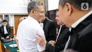 Terdakwa Agus Nurpatria tersenyum saat berjabat tangan dengan kuasa hukum usai menjalani sidang perdana di PN Jakarta Rabu (19/10/2022). Agus Nurpatria menyalami kuasa hukum dengan penuh senyuman usai menjalani sidang dengan agenda pembacaan surat dakwaan kasus obstruction of justice atau perintangan proses penyidikan terkait perkara dugaan pembunuhan berencana terhadap Nofriansyah Yosua Hutabarat atau Brigadir J. (Liputan6.com/Faizal Fanani)