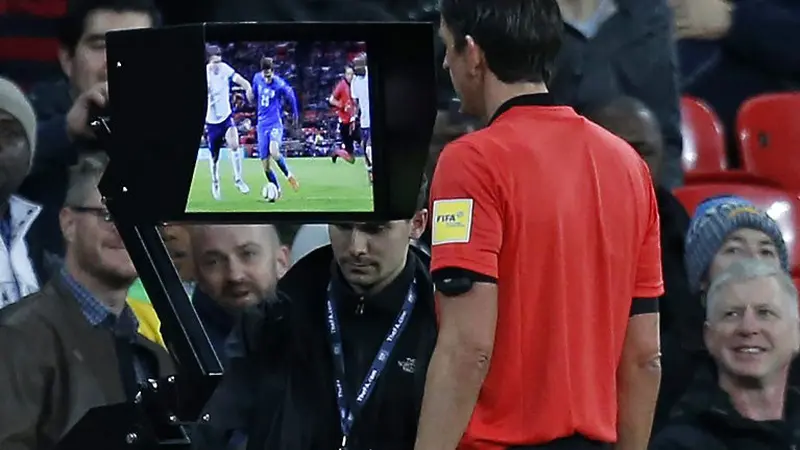 Wasit Jerman, Deniz Aytekin, mengecek layar VAR (Video Assistant Referee) pada laga persahabatan antara Inggris versus Italia di London, 27 Maret 2018. (AFP/Ian Kington)