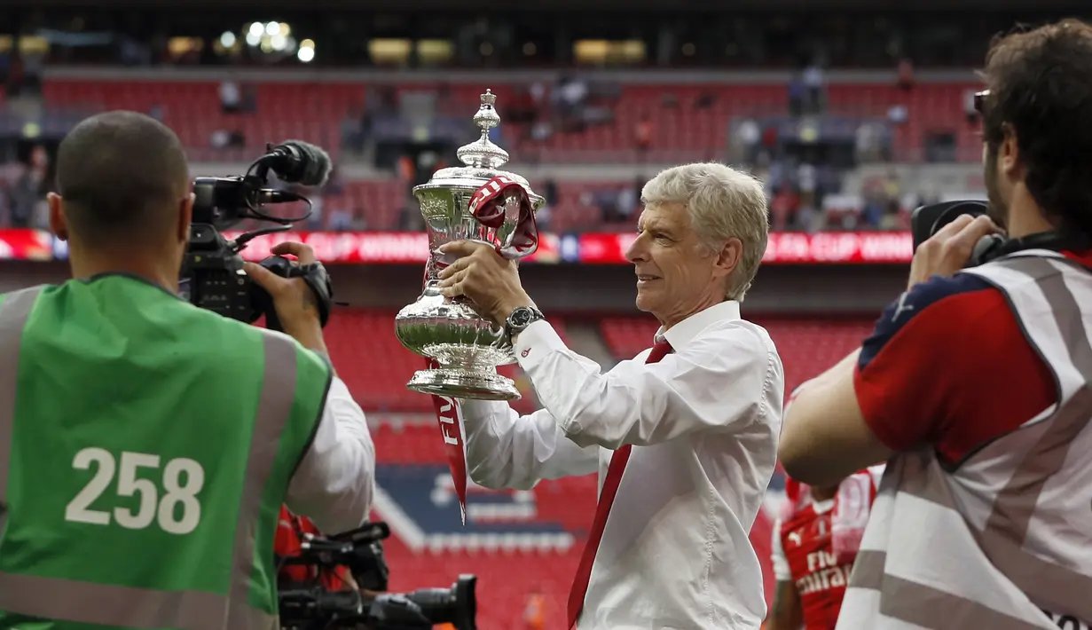 Arsene Wenger memegang trofi Piala FA 2016-2017 di Stadion Wembley, London, Sabtu (27/5). Arsenal mengalahkan Chelsea 2-1 dalam laga final tersebut. (AP Photo)